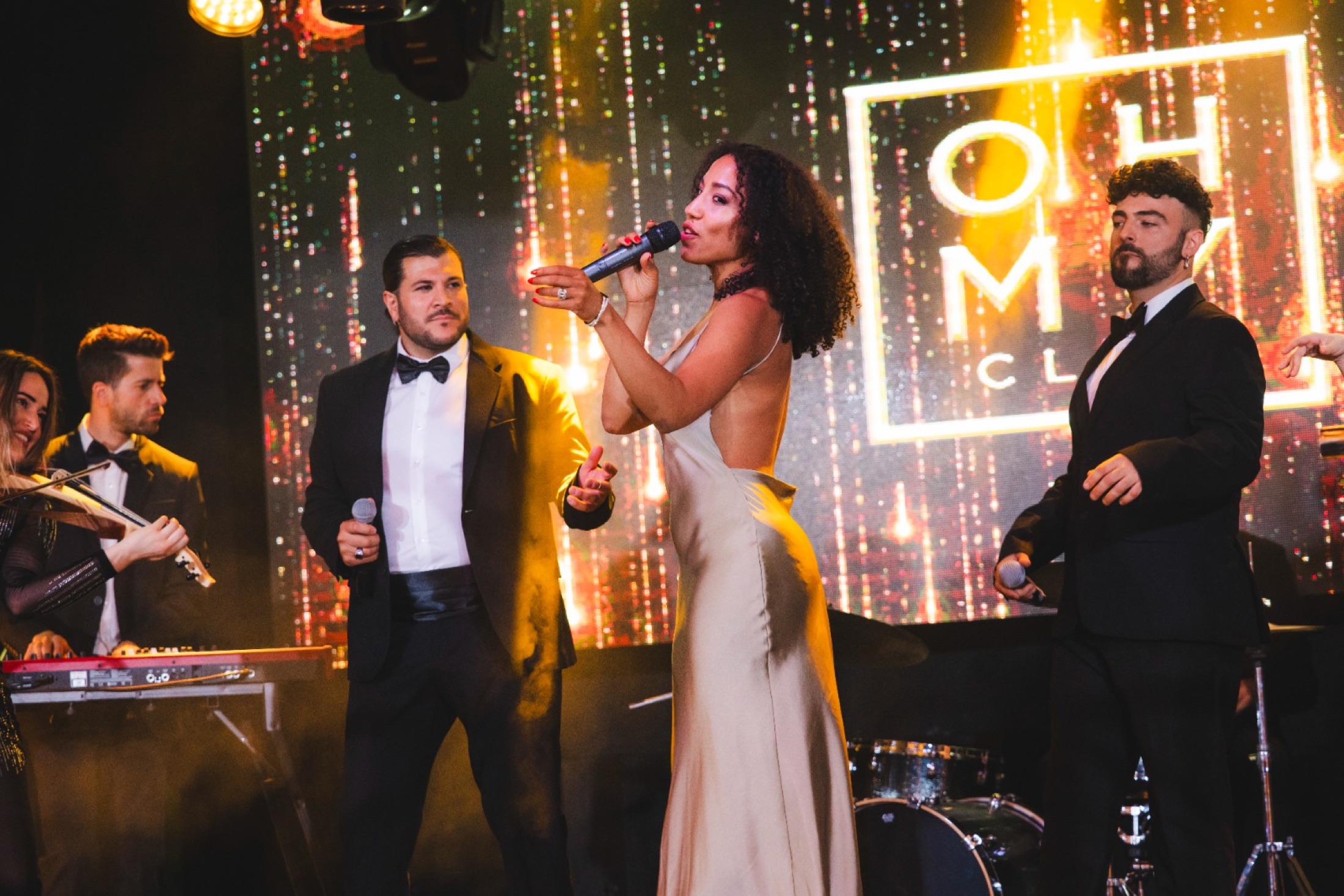 Solista con vestido dorado en un club.